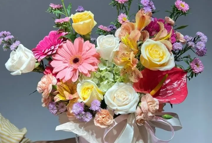 una persona sosteniendo una caja de flores