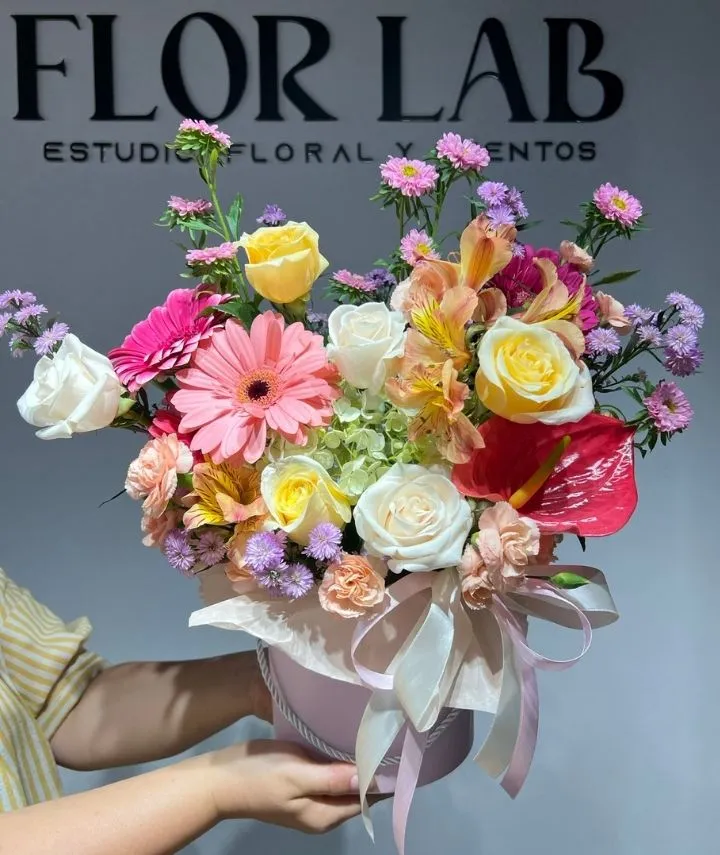 una persona sosteniendo una caja de flores