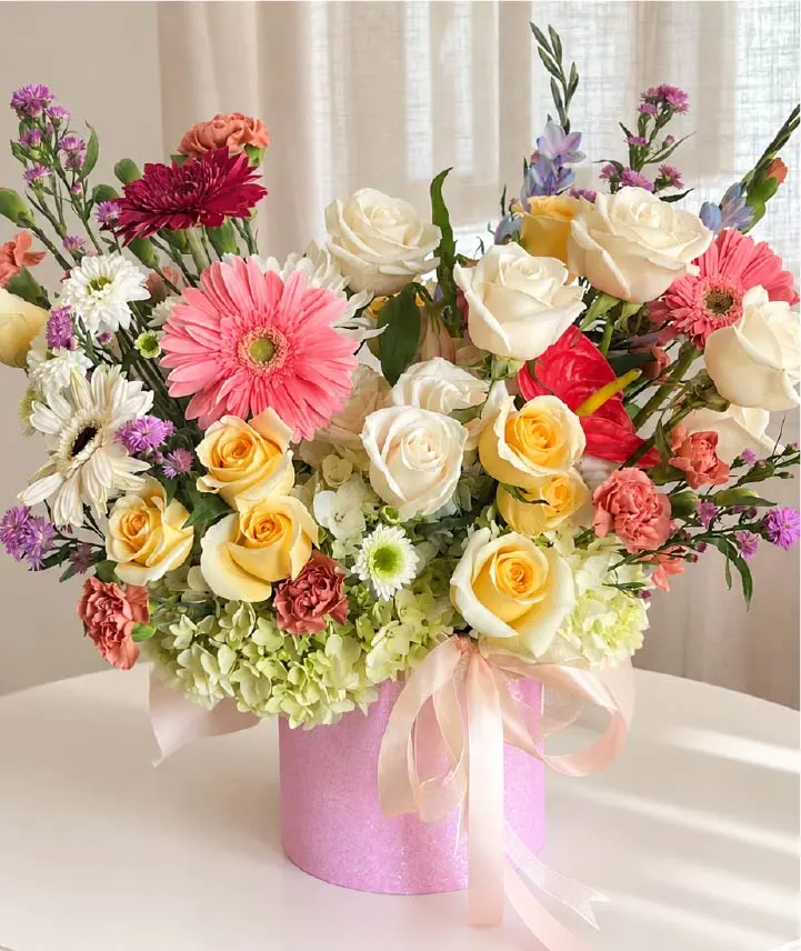 caja-floral-jardín-de-ensueño Caja floral premium con rosas blancas, gerberas rosadas, hortensias y flores mixtas en elegante caja rosada para regalo en Costa Rica.