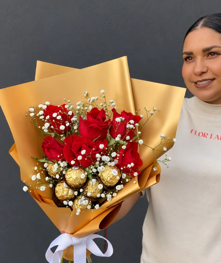 Ramo de rosas rojas premium con gypsophila blanca y chocolates Ferrero Rocher en elegante envoltura dorada.